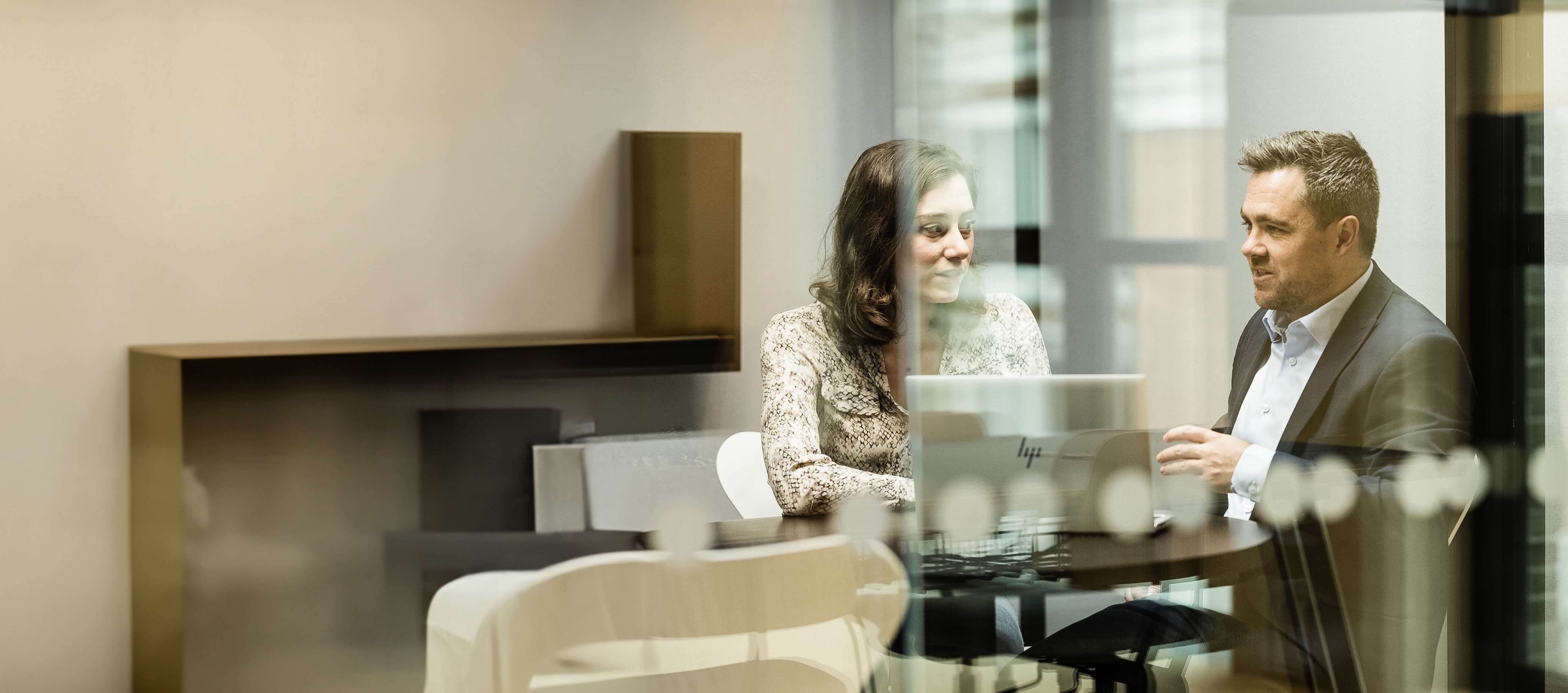 A man and woman engaged in discussion in a meeting room