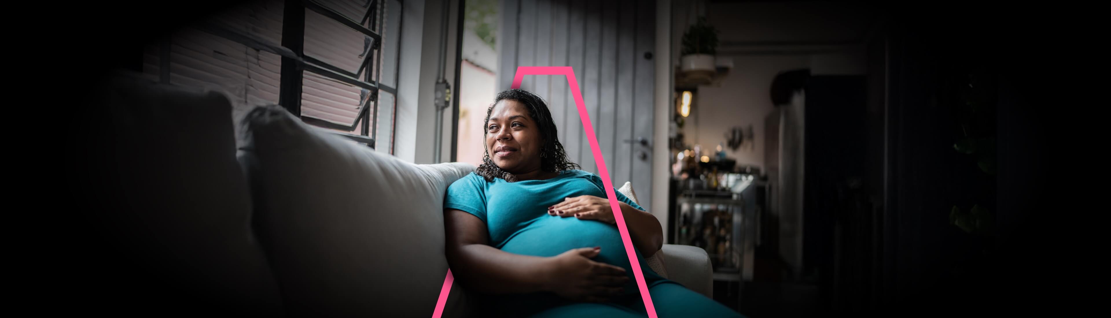A heavily pregnant woman relaxing on a couch